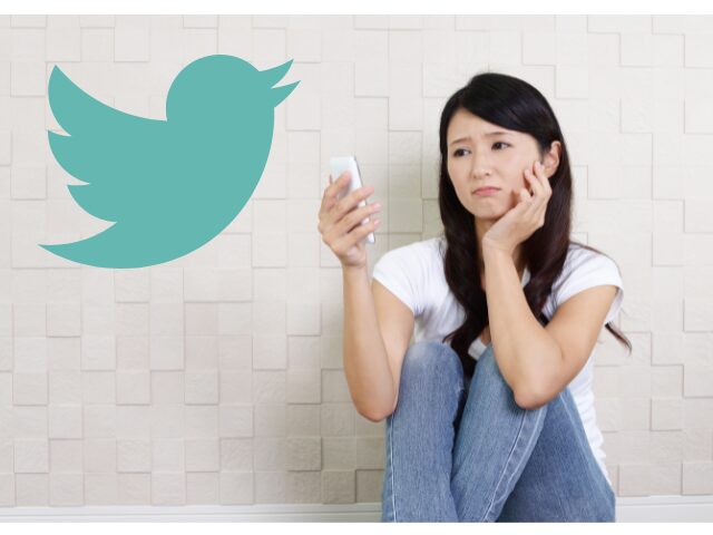 スマホを操作して悩んでいる女性